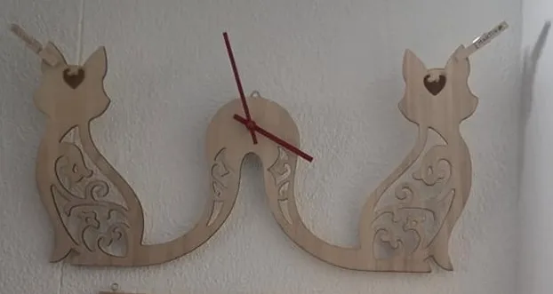 Fertige Wanduhr mit Katzenmotiv und Ranken an der Wand